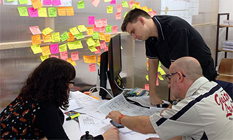 Three user experience designers discussing a sketch